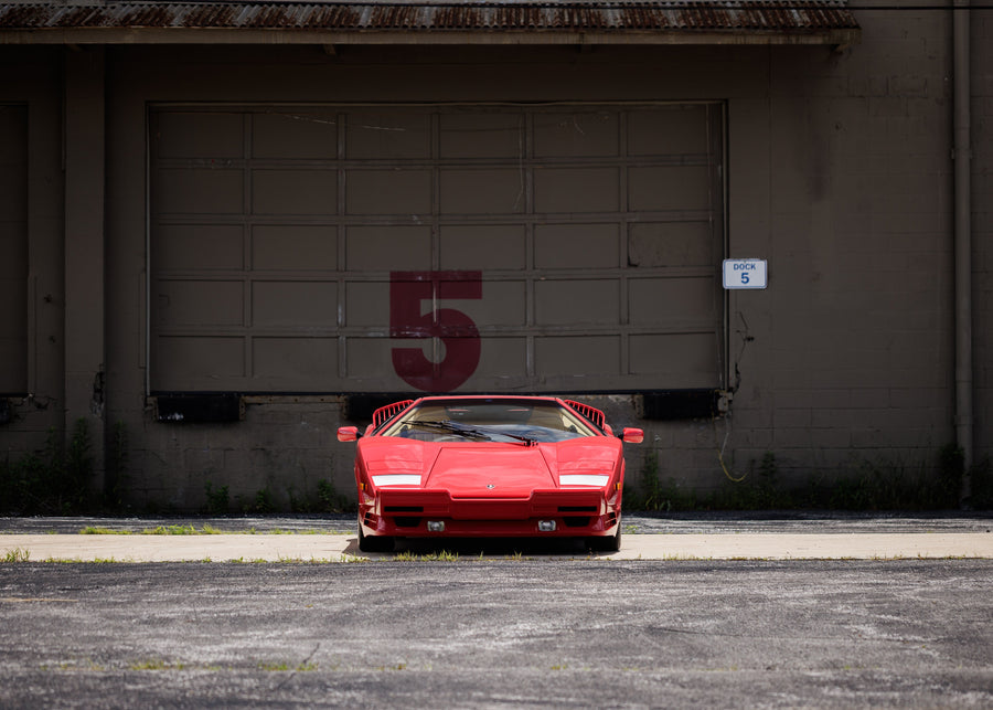 Rode Lamborghini Countach 25th Anniversario van voren, voor een garagepoort